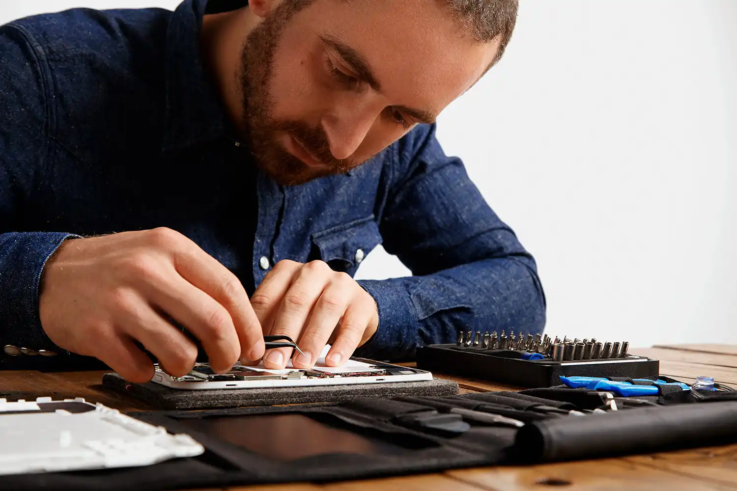 Técnico da iTelas instalando tela de iPhone na bancada